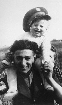 Minsk ghetto Jewish policeman carries his young cousin